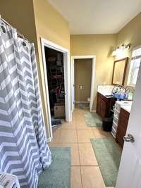 master bathroom with double vanities and walk-in closet