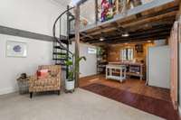 Inside the studio is a kitchen space, full bath and spiral staircase to loft area
