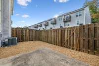 The back patio features a privacy fence and pea gravel, offering a low-maintenance outdoor space.