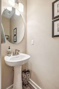 A convenient half bath with pedestal sink is located on the main level for easy access.