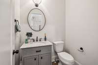 Conveniently located throughout the home are two exquisite powder rooms, each designed with impeccable attention to detail. These refined spaces feature modern vanities with marble countertops and rich gray cabinetry that offers ample storage.