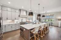 The heart of the home, this kitchen seamlessly blends beauty and functionality. Quartz countertops, a stylish tile backsplash, and under-cabinet lighting enhance the space, while ceiling-height cabinetry provides ample storage.