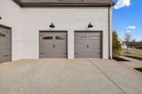 The two-car side-entry garage, along with the separate one-car carriage-style garage, provides ample space for vehicles, a golf cart, and lawn equipment.
