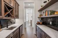Positioned between the dining room and kitchen, it enhances the home’s seamless flow.
