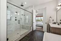 Tile flooring, a free-standing soaking tub, and a spacious walk-in shower with tile surround and built-in bench enhance the spa-like atmosphere. A private water closet adds an extra touch of comfort and privacy, making this bath a true sanctuary.