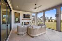 This spacious covered, screened-in porch with a cozy fireplace is perfect for relaxing or entertaining, offering plenty of room for outdoor furniture, family, and guests.