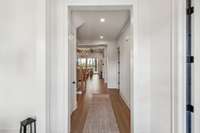 The open foyer seamlessly connects to the office & dining room, creating a welcoming flow. Stunning sightlines draw your eye to the family room, where a wall of windows frames picturesque views of the covered porch.