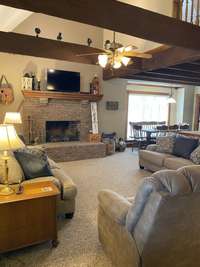 Beamed and high ceilings in this open living area with gas fireplace and wood mantel.  Beautiful!