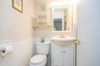 The hallway by the closet leads to a convenient powder room.