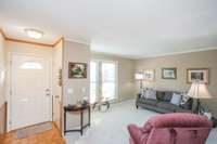 All the carpeting throughout the home is brand-new. Morning light streams through the windows of the living room.