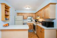 The kitchen is equipped with a refrigerator, electric range, and a brand-new dishwasher.