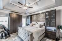 The primary bedroom boasts ceramic wood look floors, double tray ceiling, and custom California closet storage in abundance!