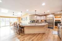 This exceptionally large kitchen has been completely remodeled. Taken down to the studs and rebuilt from ground up. Elegant lighting, glazed cabinetry, quartz countertops, hardwood floors. The sliding doors along the far wall lead out to the pool.
