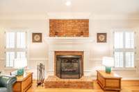 All windows throughout the home have custom made wood plantation blinds as seen to left and right of the living room fireplace.