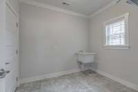 Large laundry room with utility sink and tile floors.