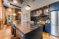 The fully equipped kitchen has a gas Bertazzoni Stove, range hood and a stunning 8' quartz island