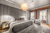 An Oly Studio cloud chandelier hovers effortlessly above the bed, while electronic shades and drapes glide over soundproof windows to protect your slumber.