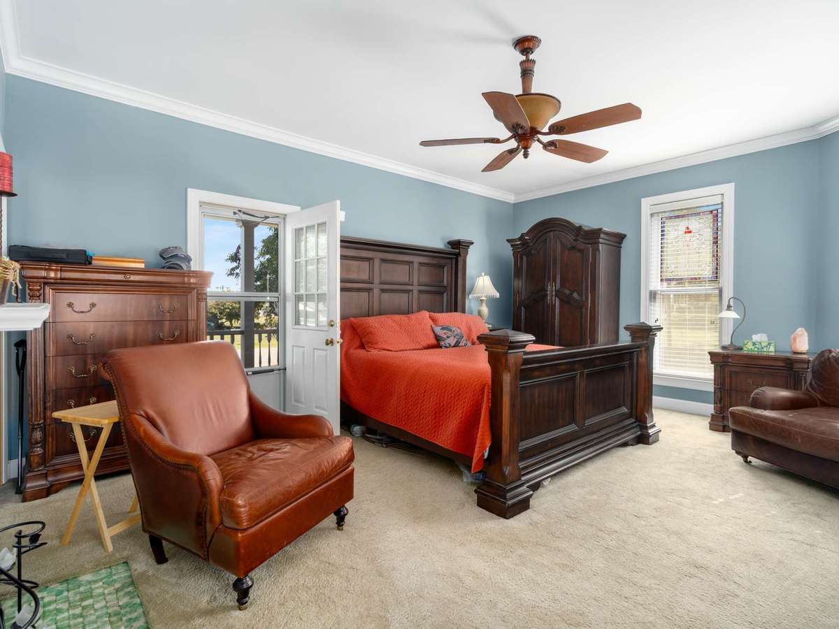 This bedroom has doors leading onto the upper covered front and back porches.