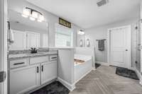 Primary bathroom with separate vanities and a huge walk-in closet