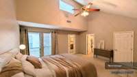 Spacious Primary Bedroom Suite features vaulted ceilings & abundant natural light w/views of the private, fenced pea gravel courtyard. Room includes cozy carpeting, two generous walk-in closets, & an en-suite bath w/ a tub/shower combo & vanity.