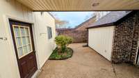 From the serene Primary Bedroom, step into the private courtyard through a covered walkway, leading directly to the spacious, oversized two-car garage.