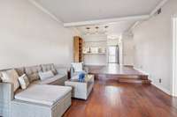 An open-concept floor plan extends seamlessly from the entry to the living area, highlighted by a two-step sunken transition that adds architectural character and gently defines the space.