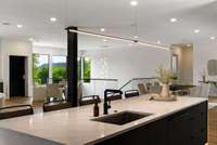 The quartz waterfall island features a cabinet front dishwasher.