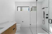 Guest suite bath with floating vanity and glass shower