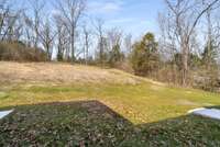 The lot is 1.64 acres and the property line extends well into the tree line at the top of the hill.