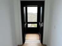 Motorized elevator doors and hillside view from inside the elevator