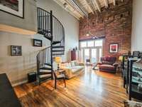 Spacious living room with soaring ceiling & gorgeous hardwood flooring.