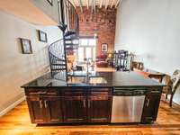 Eating island, staircase to the loft bedroom & view into the living room.
