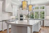 The kitchen features double ovens by Monogram, a gas cooktop and the stunning over-sized island.