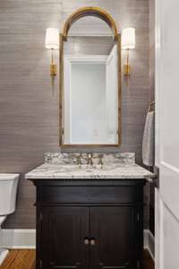 The perfectly private half bath with grasscloth wall paper and stunning fixtures.