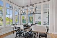 Windows opening to the outdoor patio bring indoor and outdoor living to the eat-in dining area.
