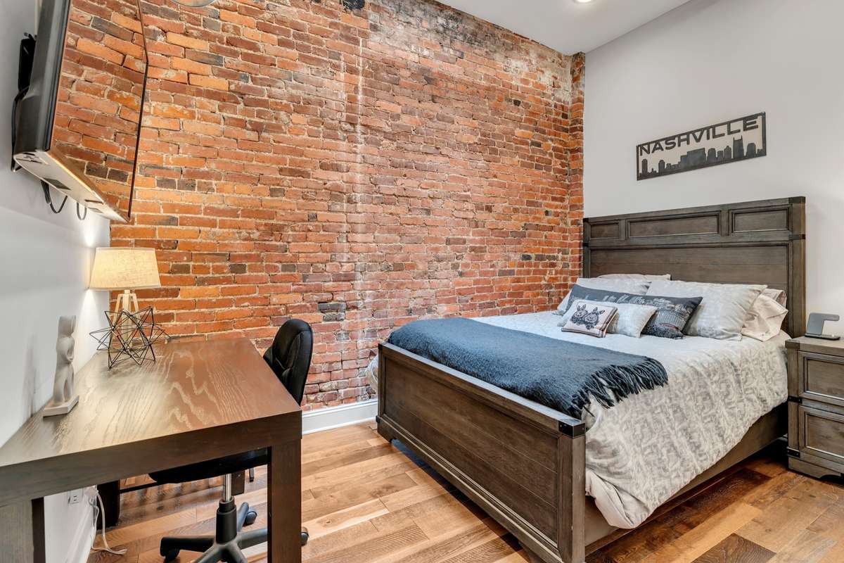 Guest Bedroom 
Featuring exposed brick, custom closet system and SKYLIGHT!!