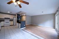 Open kitchen, dining, and living room with access to deck on the back and large windows in the dining room that provide wonderful natural light