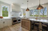 This kitchen's striking counter-to-ceiling backsplash and Waterworks + deVOL faucets tie together the kitchen’s high-end aesthetic.