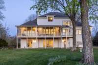 A timeless Southern beauty—this three-story estate sits gracefully on sprawling acreage, offering a picturesque rear view framed by wide porches, mature trees, and the peaceful rhythm of country living.