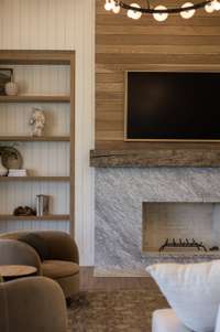 The wood-burning fireplace serves as the centerpiece of the great room, perfect for gatherings or quiet evenings.