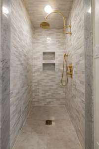 The wellness level bathroom features artisan Clé Moroccan zellige tile shower, Waterworks fixtures, and frameless shower door, blending timeless design with high-end craftsmanship.