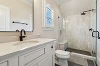 Newly remodelled bath w/ marble tile & bench.