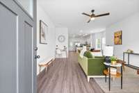Open concept main level, large living room with ceiling fan and LVT flooring.