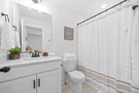 Full bathroom in second suite with custom cabinets and quartz countertops