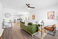 Open concept main level, large living room with ceiling fan and LVT flooring.