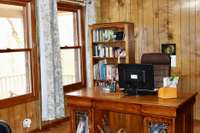 Spacious and bright office space with wood paneling and plenty of room for a home office or welcoming parlor area.  Curtains do not convey with property