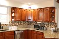 Absolutely gorgeous Cherry cabinets with Granite countertops and tile backsplash.  An abundance of cabinets