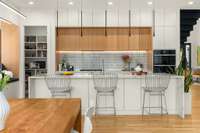 The chef's kitchen features waterfall quartz countertops, Jenn-Air appliances + reverse-osmosis water filtration system.