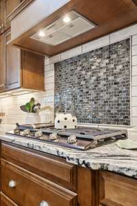 A Gas Cooktop with a classic backsplash.