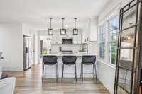 Renovated Kitchen with Quartz Countertops, Tile Backsplash, White Cabinetry, Farmhouse Sink, Gas Range & SS Appliances